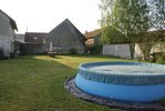 Voici l'arrière de la maison, ou il y a maintenant une barrière en bois tout le long pour sécurisé les enfants, Ici c'est plein soleil sauf ou est situé les fils à linge et rubarbe.<br /><br />Ici nous ferons une terasse moitié bois moitié carrelage, j'aimerai aménager le mur en parpaing, pour le moment il y a un peu de lierre qui pousse dessus, nous le taillons.<br /><br />Il y a aussi une balançoire pour les enfants au fond à droite