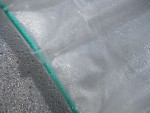 Détail de l'ourlet, à l'intérieur passe une corde qui permet de tendre la bâche sur la serre.